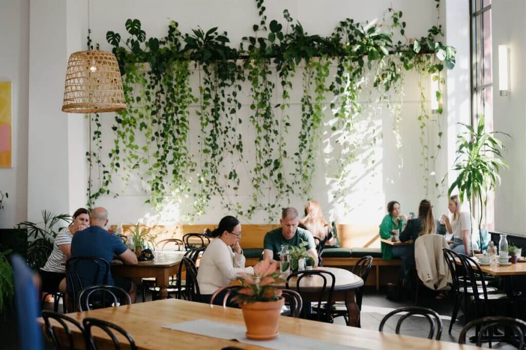 Plant-based restaurant interior with people sitting at tables