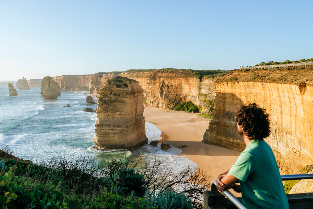 Australia, Victoria, man watching sunset at the Twelve Apostles iconic place on the Great Ocean Road.