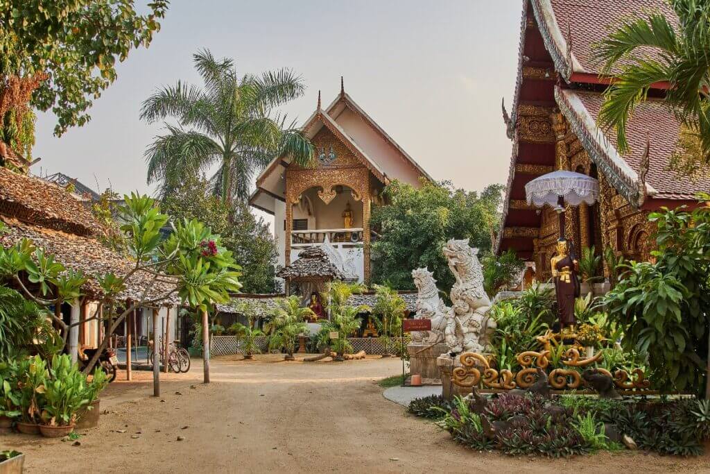 Visiting temples are among the best things to do in Chiang Mai. Temple Wat Mahawan is surrounded by mythological lion sculptures and tropical greenery.