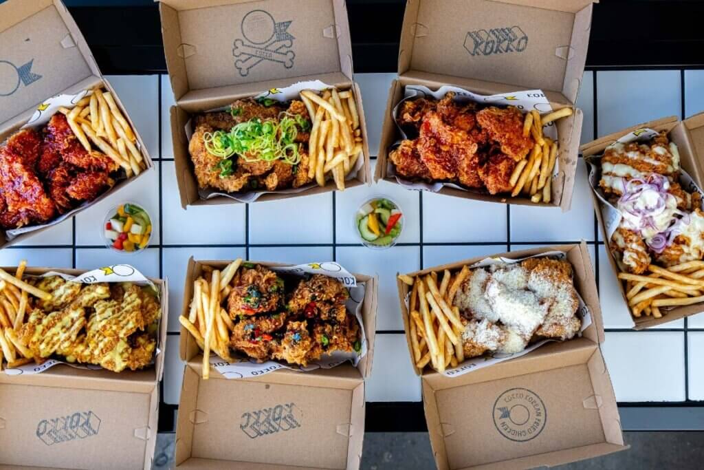 Takeout boxes with Korean-style fried chicken and fries