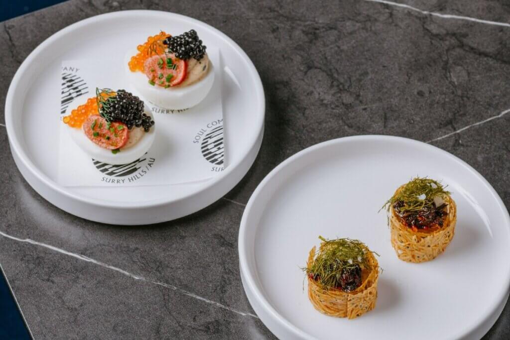 Two plates with two small food creations per plate
