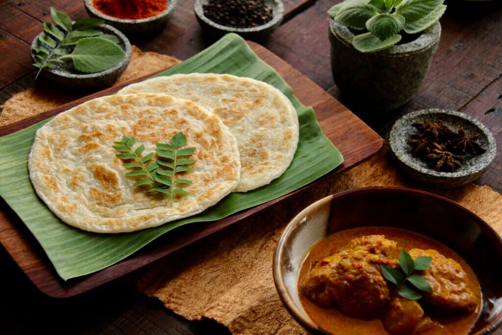 Roti prata served with curry is a typical Singaporean breakfast dish. 